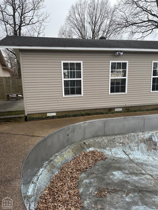 view of side of home featuring crawl space and fence