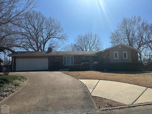 single story home with stone siding, driveway, a chimney, and an attached garage