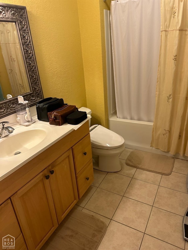 bathroom featuring a textured wall, tile patterned flooring, toilet, vanity, and shower / bath combination with curtain