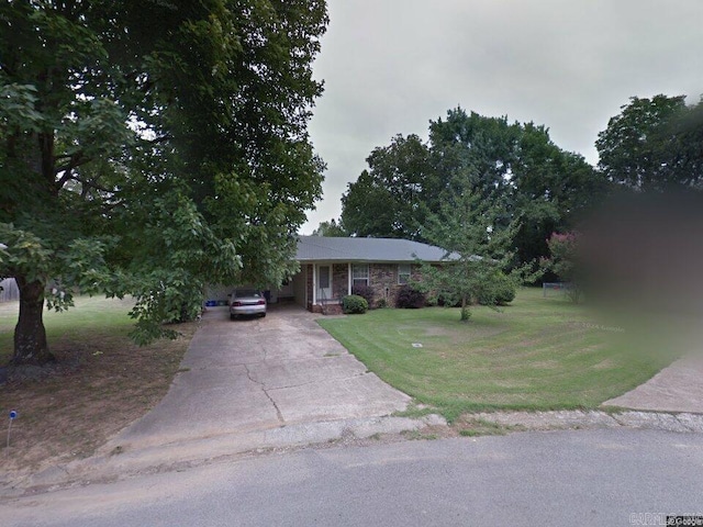 view of front of home with a carport, a front lawn, concrete driveway, and brick siding