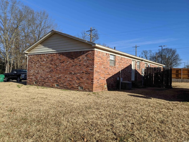 view of side of home featuring central AC, brick siding, crawl space, and fence