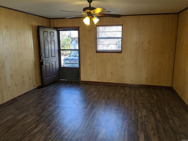 empty room featuring dark wood-type flooring, visible vents, ceiling fan, and baseboards