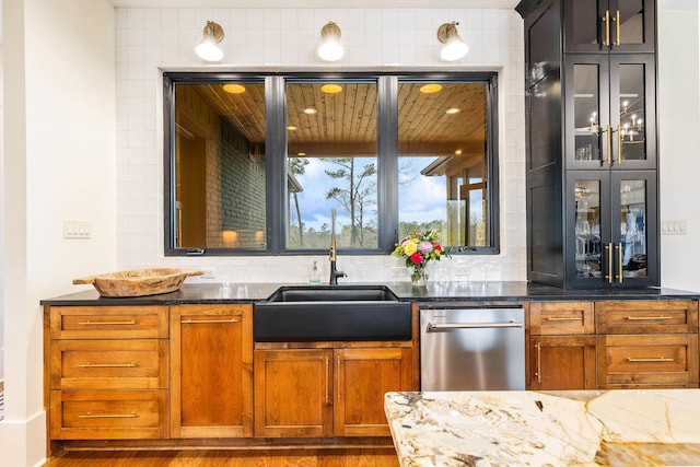 bar with tasteful backsplash, a sink, and stainless steel dishwasher