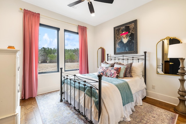 bedroom featuring wood finished floors, a ceiling fan, and baseboards