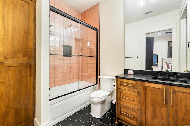 full bathroom with enclosed tub / shower combo, toilet, vanity, visible vents, and tile patterned floors