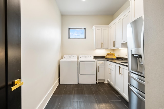 clothes washing area featuring laundry area, washing machine and clothes dryer, and baseboards