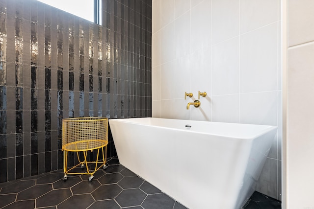 full bathroom featuring a soaking tub, tile walls, and tile patterned floors