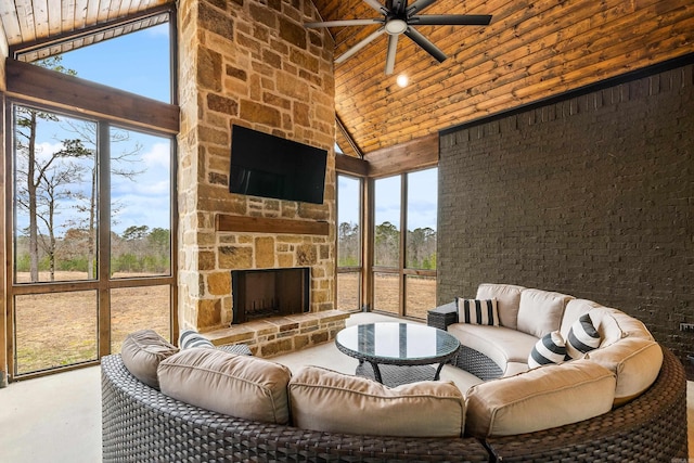 living room featuring high vaulted ceiling, wood ceiling, an outdoor stone fireplace, and ceiling fan