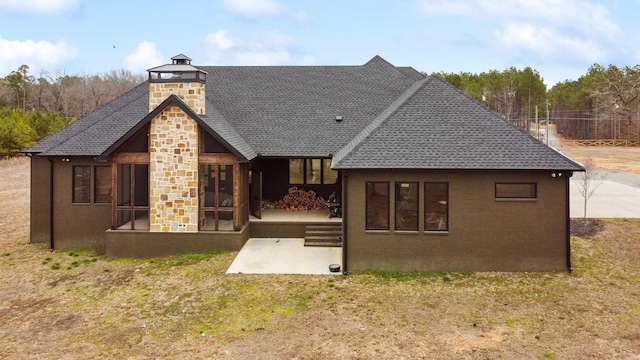 rear view of property with a sunroom, a yard, and a patio