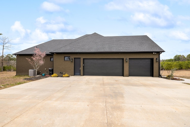 view of front of house with brick siding, roof with shingles, concrete driveway, an attached garage, and cooling unit