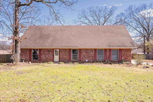 view of front of property featuring brick siding, a shingled roof, fence, and a front yard