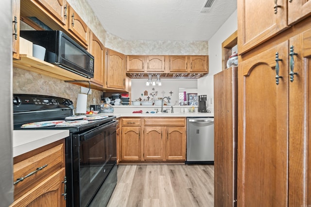 kitchen with black appliances, light wood-type flooring, light countertops, and visible vents