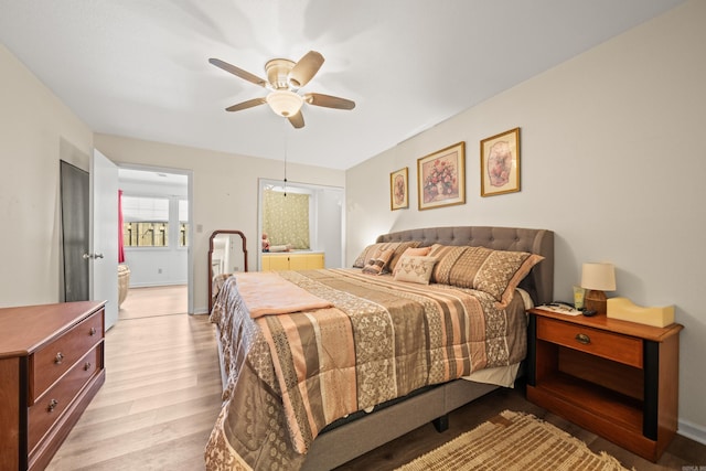 bedroom with light wood-type flooring, ensuite bath, a ceiling fan, and baseboards