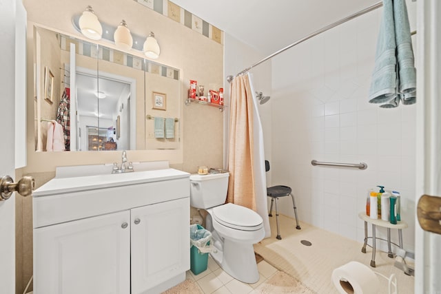 bathroom featuring toilet, tile patterned flooring, tiled shower, and vanity