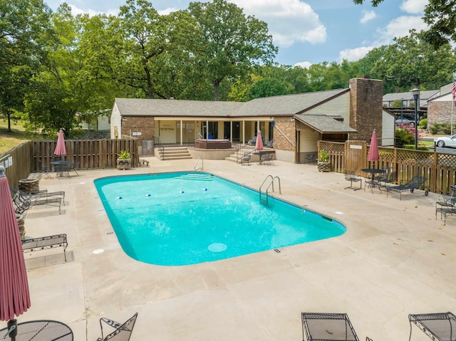 community pool featuring entry steps, a patio, and fence