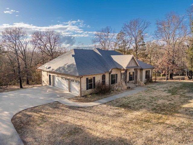 view of front of home featuring brick siding, roof with shingles, concrete driveway, a garage, and a front lawn