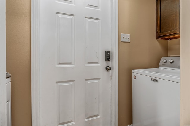 washroom featuring washer / clothes dryer and cabinet space