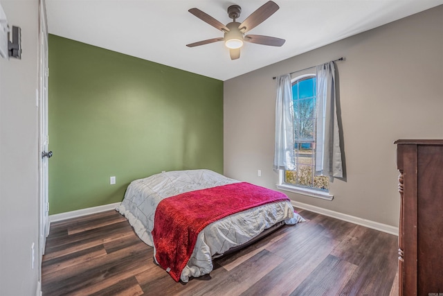 bedroom with multiple windows, baseboards, and wood finished floors