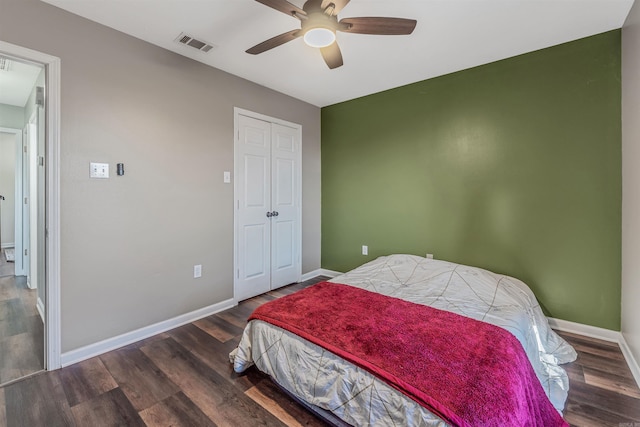 bedroom featuring wood finished floors, a ceiling fan, visible vents, baseboards, and a closet