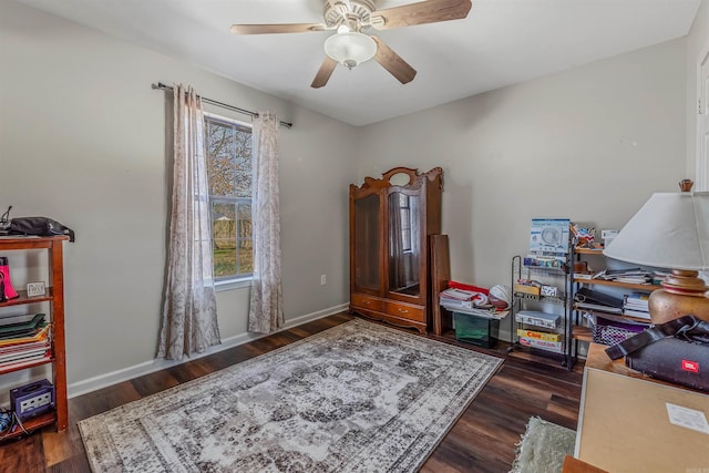 interior space with a ceiling fan, baseboards, and wood finished floors