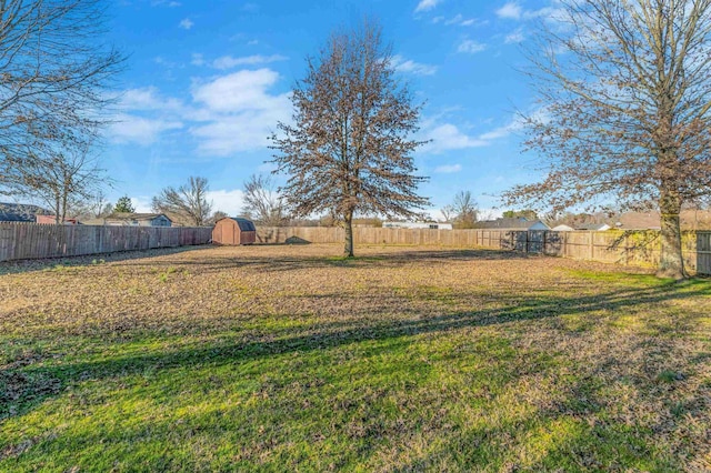 view of yard featuring a fenced backyard, an outdoor structure, and a storage shed