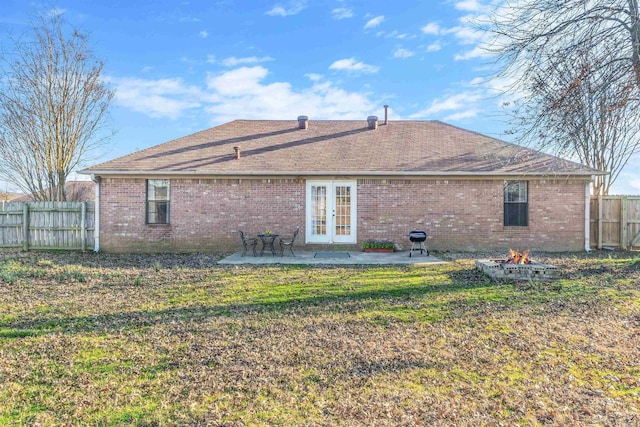 back of property featuring brick siding, a yard, a patio, fence, and a fire pit