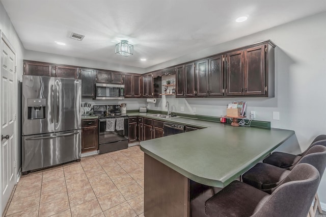 kitchen featuring light tile patterned floors, visible vents, stainless steel appliances, dark brown cabinets, and a sink