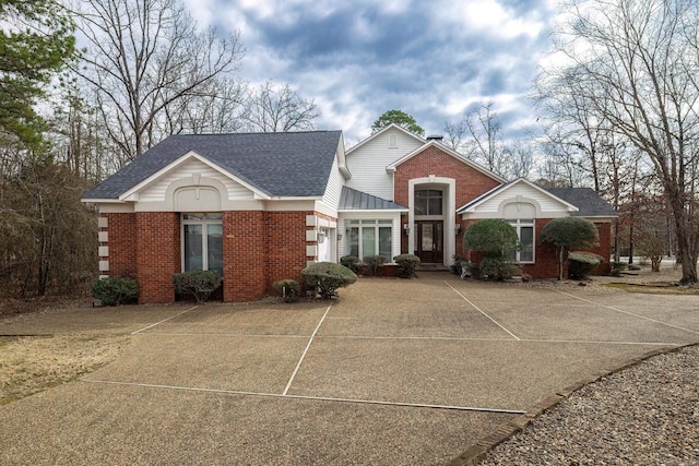 view of front of property with brick siding and a shingled roof