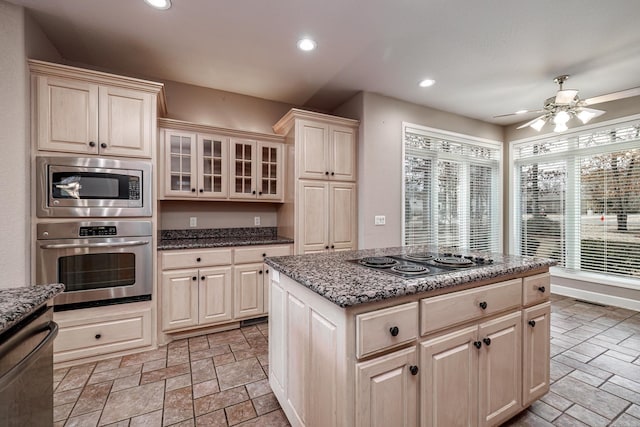 kitchen featuring stone tile floors, appliances with stainless steel finishes, stone countertops, and recessed lighting