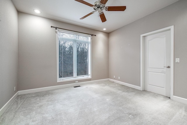 empty room with carpet floors, recessed lighting, visible vents, and baseboards