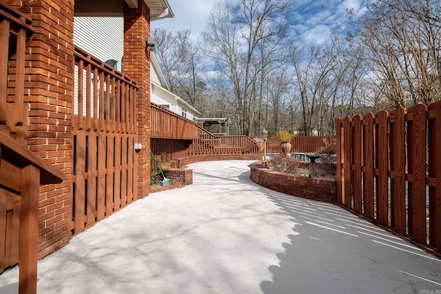 view of patio featuring fence and a deck