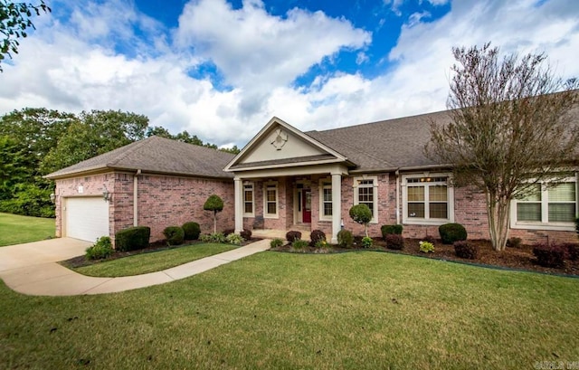 neoclassical / greek revival house featuring a garage, brick siding, driveway, and a front yard