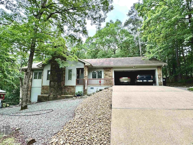 view of front facade featuring a garage, stone siding, covered porch, and concrete driveway