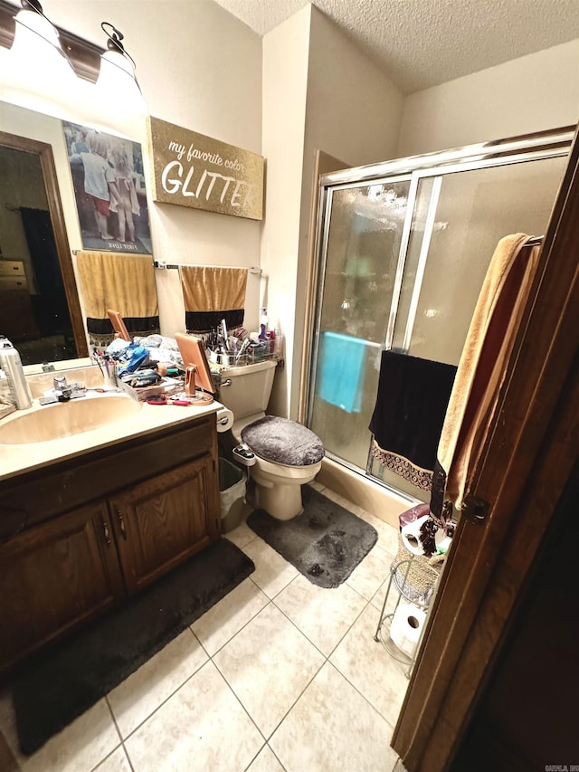 full bath with a textured ceiling, a shower stall, and tile patterned floors