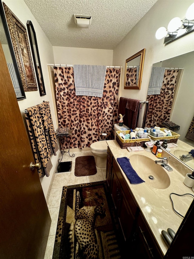 full bathroom with toilet, shower / tub combo with curtain, tile patterned floors, a textured ceiling, and vanity