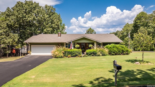 ranch-style house featuring a front yard, driveway, a chimney, and an attached garage