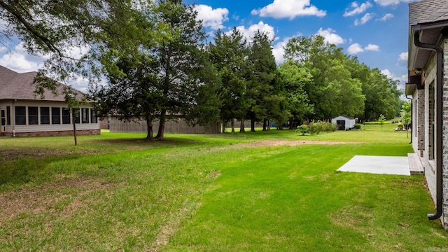 view of yard with a storage unit, a patio area, and an outbuilding