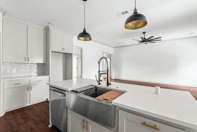 kitchen with stainless steel dishwasher, a sink, white cabinetry, visible vents, and pendant lighting
