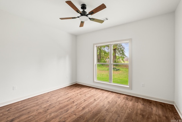 spare room with wood finished floors, ceiling fan, and baseboards