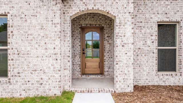 view of exterior entry featuring brick siding