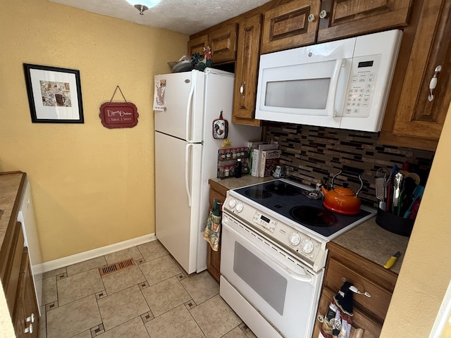 kitchen with a textured ceiling, white appliances, visible vents, baseboards, and decorative backsplash