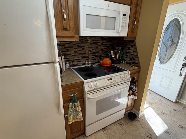 kitchen with tasteful backsplash, white appliances, and brown cabinets