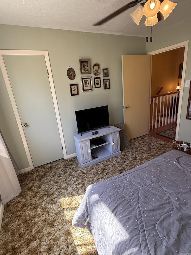 bedroom with a textured ceiling, ceiling fan, and carpet flooring