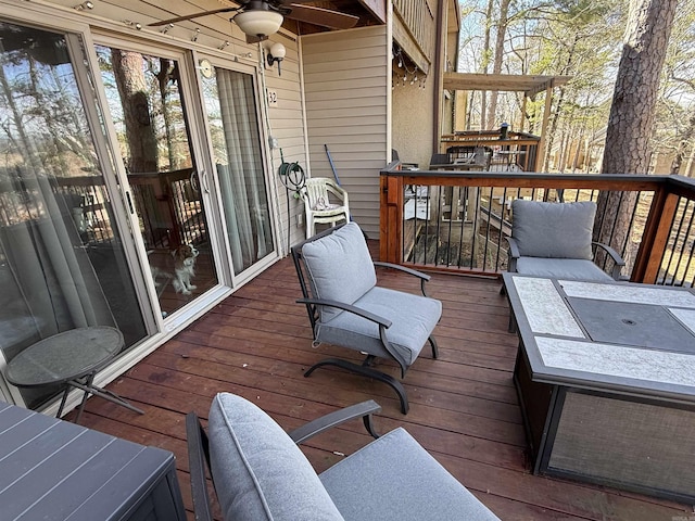 wooden deck featuring outdoor dining area and a ceiling fan