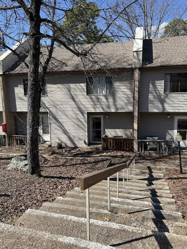 view of property exterior featuring roof with shingles and a chimney