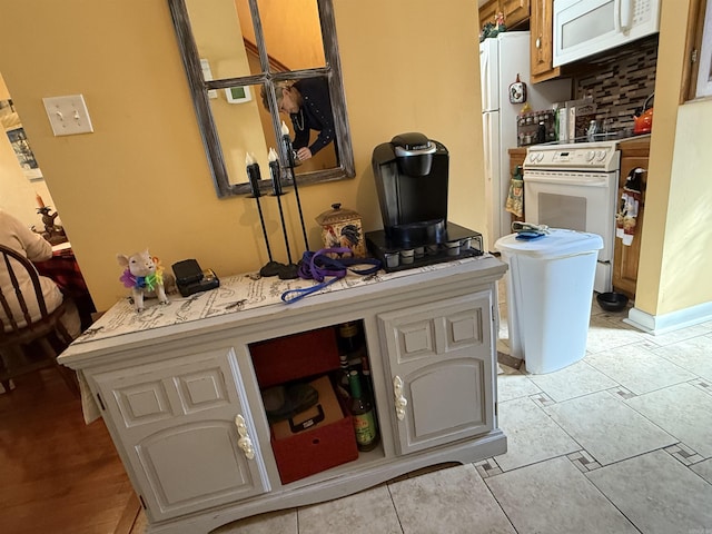 kitchen with light countertops, white appliances, and decorative backsplash