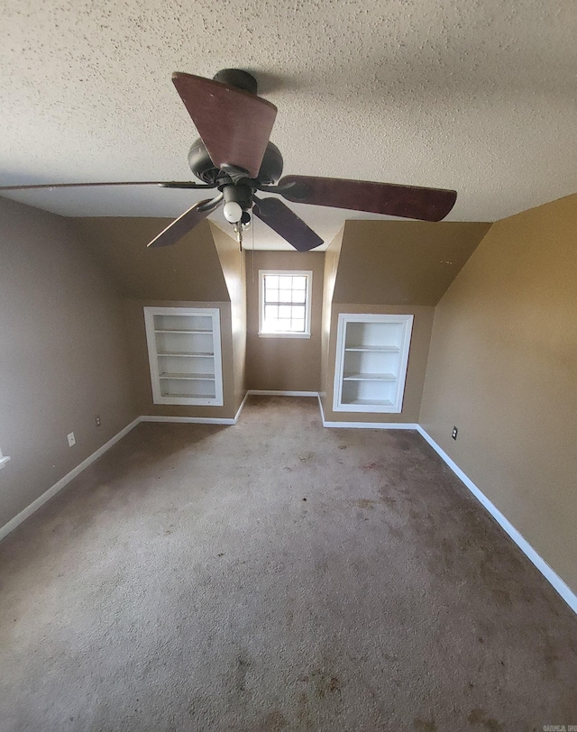 bonus room with built in features, carpet, a textured ceiling, and baseboards