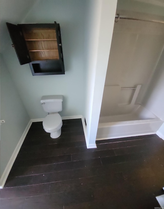 bathroom featuring toilet, baseboards, a shower, and hardwood / wood-style floors