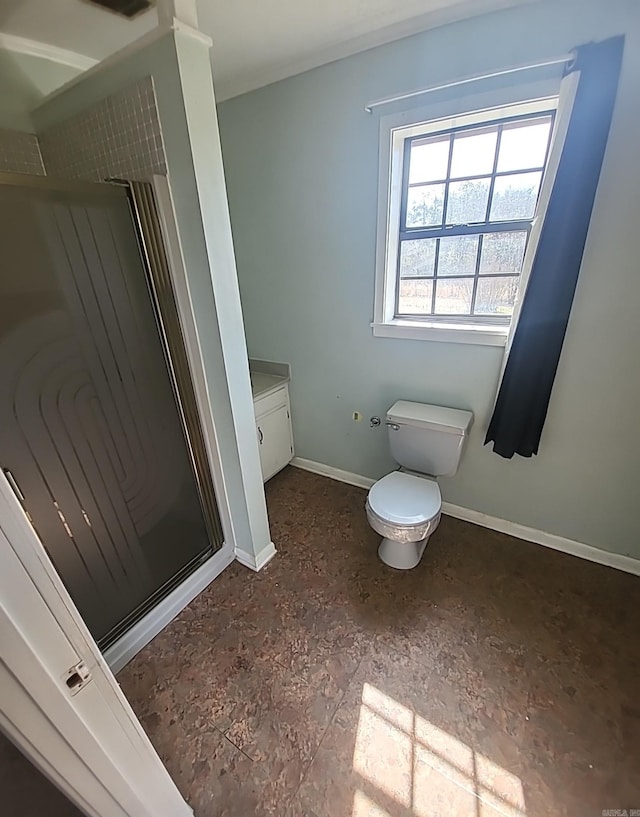 full bathroom with toilet, a shower stall, baseboards, and vanity