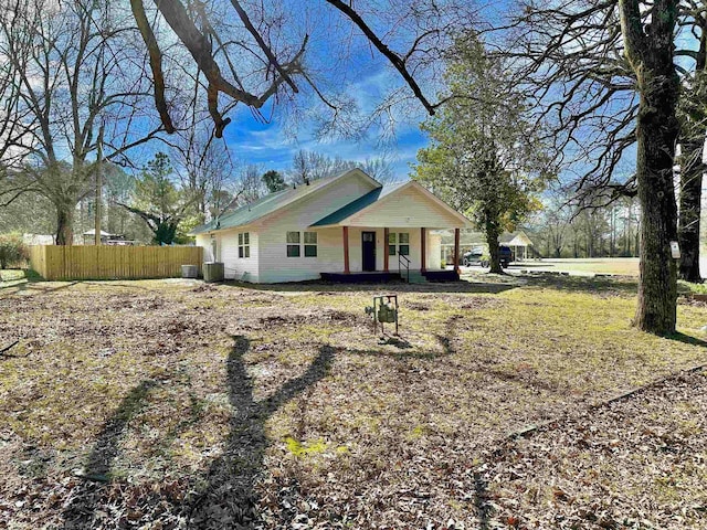 view of front of home with central AC unit, fence, and a porch